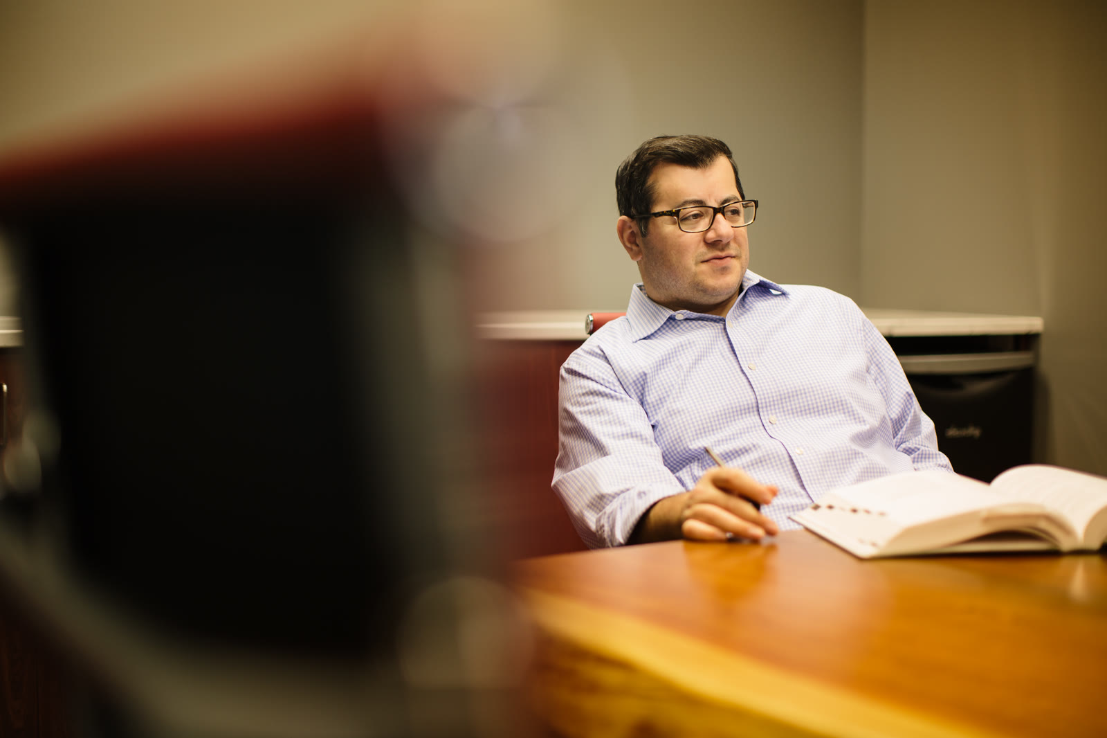 Frank Younes working at his desk with a case book